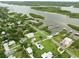 Aerial view of a residential area with a home near a river, surrounded by trees and well-kept lawns at 216 N Riverside Dr, Edgewater, FL 32132
