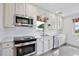 Well-lit kitchen with white cabinets, modern appliances, and a window above the sink at 216 N Riverside Dr, Edgewater, FL 32132