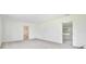 Bright living room featuring neutral carpet, white walls, and entryways to other parts of the home at 216 N Riverside Dr, Edgewater, FL 32132