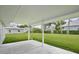 Covered patio overlooking a large, well-maintained lawn and neighboring houses, perfect for outdoor relaxation at 216 N Riverside Dr, Edgewater, FL 32132
