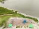 Aerial view of a community playground, swings, slide, and a green space near the waterfront at 216 N Riverside Dr, Edgewater, FL 32132