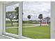Window view of a lush green lawn, palm trees, and a glimpse of the neighborhood at 216 N Riverside Dr, Edgewater, FL 32132