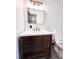 Bathroom with a modern vanity, white countertop, decorative mirror and lighting, and tile backsplash at 2342 Alice Ave, Eustis, FL 32726