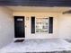 Inviting front porch with a black front door, matching shutters, and a welcome mat at 2342 Alice Ave, Eustis, FL 32726
