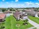 Aerial view of a one-story home in a residential area, surrounded by green lawns and mature trees at 2713 Eagle Glen Cir, Kissimmee, FL 34746