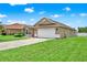 Exterior view of a one-story home featuring a two-car garage and well-maintained landscaping at 2713 Eagle Glen Cir, Kissimmee, FL 34746