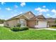 Side view of a cozy one-story home with a lush green lawn and a paved driveway at 2713 Eagle Glen Cir, Kissimmee, FL 34746