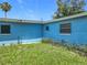 Property's blue house with a grassy backyard and minimal plants at 2728 Hertha Ave, Orlando, FL 32826