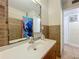 Bathroom featuring a mirror, a vanity with sink, and a shower with a curtain and tiled walls at 2728 Hertha Ave, Orlando, FL 32826