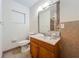 This bathroom features a wooden vanity, a toilet, and a mirror framed with decorative tiles at 2728 Hertha Ave, Orlando, FL 32826