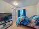 Bedroom with blue bedspread, window with blue curtains, TV, closet and carpet floors at 2728 Hertha Ave, Orlando, FL 32826