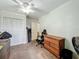 Bedroom with wooden dresser, ceiling fan, chair, and storage boxes with carpet flooring at 2728 Hertha Ave, Orlando, FL 32826