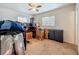 Bedroom with a ceiling fan, two windows and moving boxes on top of brown carpet at 2728 Hertha Ave, Orlando, FL 32826