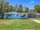 Charming single-story home with a blue exterior, screened in porch, and well-maintained lawn at 2728 Hertha Ave, Orlando, FL 32826