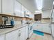 Bright kitchen featuring white cabinets, matching appliances, and a stylish backsplash at 2728 Hertha Ave, Orlando, FL 32826