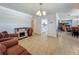 Cozy living room with tile flooring, a decorative fireplace, and a view of the adjacent dining room at 2728 Hertha Ave, Orlando, FL 32826