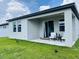 Spacious backyard showcasing a green lawn, covered patio with outdoor seating, and seamless indoor-outdoor living at 2824 Neverland Dr, New Smyrna Beach, FL 32168