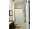 Well-lit bathroom showcasing a shower-tub combo with a stylish curtain, vanity with granite countertop, and modern toilet at 2824 Neverland Dr, New Smyrna Beach, FL 32168