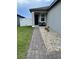 Cozy front porch featuring brick walkway, decorative stones, and a black entry door at 2824 Neverland Dr, New Smyrna Beach, FL 32168