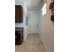 Hallway features a white door, neutral paint, and tile floors leading to the kitchen at 2824 Neverland Dr, New Smyrna Beach, FL 32168
