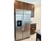 Stainless steel refrigerator, brown cabinets and granite counter top in the kitchen area at 2824 Neverland Dr, New Smyrna Beach, FL 32168
