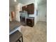 Kitchen area with stainless steel fridge, dark brown cabinetry and granite countertops at 2824 Neverland Dr, New Smyrna Beach, FL 32168