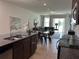 Open-concept living space shows kitchen island, dining area, and living room with sliding glass doors at 2824 Neverland Dr, New Smyrna Beach, FL 32168