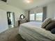 Bright main bedroom features a light-colored carpet, dresser, and two windows with curtains at 2824 Neverland Dr, New Smyrna Beach, FL 32168