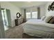 Bright main bedroom has carpet, a dresser, two windows with curtains and exterior access at 2824 Neverland Dr, New Smyrna Beach, FL 32168