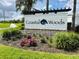 Beautiful entrance sign for Coastal Woods community with lush landscaping and vibrant flowers at 2824 Neverland Dr, New Smyrna Beach, FL 32168
