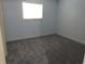 Bedroom with light blue walls, grey carpet, and a bright window at 2864 N Powers Drive # 156, Orlando, FL 32818