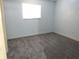 Bedroom with light blue walls, grey carpet, and a bright window at 2864 N Powers Drive # 156, Orlando, FL 32818