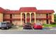 Apartment building featuring a red roof, balcony, and reserved parking spaces in the front at 2864 N Powers Drive # 156, Orlando, FL 32818