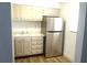 Cozy kitchen featuring stainless steel refrigerator, white cabinets, and wood-look flooring at 2864 N Powers Drive # 156, Orlando, FL 32818