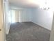 Inviting living room with a light blue paint, grey carpet, and bright sliding glass doors at 2864 N Powers Drive # 156, Orlando, FL 32818