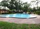 Community pool surrounded by brick pavers and lush green grass at 2864 N Powers Drive # 156, Orlando, FL 32818