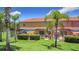 Backyard showing covered patio area, tropical landscaping, and green lawn at 3010 Secret Lake Dr, Kissimmee, FL 34747