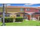 Backyard view of covered patio and grass area with green landscaping hedge at 3010 Secret Lake Dr, Kissimmee, FL 34747