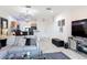 Open-concept living room featuring tile floors, modern decor, and a view of the kitchen with bar seating at 3010 Secret Lake Dr, Kissimmee, FL 34747