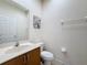 Neutral powder room with a wood vanity, toilet, and framed art at 3010 Secret Lake Dr, Kissimmee, FL 34747