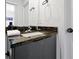 A modern bathroom featuring a granite countertop and a sleek, gray cabinet at 3308 Tranquil Trl, Kissimmee, FL 34747