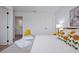 Fresh, modern bedroom with bright white walls and linens and a vibrant yellow chair at 3308 Tranquil Trl, Kissimmee, FL 34747