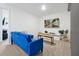 Bright living room with blue sofa, neutral carpet, and large screen TV at 3308 Tranquil Trl, Kissimmee, FL 34747