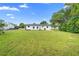 Large backyard with a well-maintained lawn and the rear exterior of the house at 36 Morning Glory Dr, Debary, FL 32713