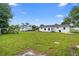 Spacious backyard featuring lush green grass and a white house exterior under a bright blue sky at 36 Morning Glory Dr, Debary, FL 32713