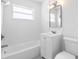 Bathroom featuring white tile, a tub, a mirror with lighting, and a toilet at 36 Morning Glory Dr, Debary, FL 32713