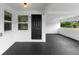 A spacious and modern porch featuring a dark door and smooth concrete flooring at 36 Morning Glory Dr, Debary, FL 32713
