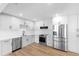 Modern kitchen with stainless steel appliances, quartz countertops, white cabinets, and hardwood flooring at 36 Morning Glory Dr, Debary, FL 32713