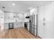 Modern kitchen featuring stainless steel appliances, white cabinetry, and wood-look flooring at 36 Morning Glory Dr, Debary, FL 32713