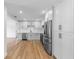 Modern kitchen featuring hardwood floors, white cabinets, stainless steel appliances, and quartz countertops at 36 Morning Glory Dr, Debary, FL 32713